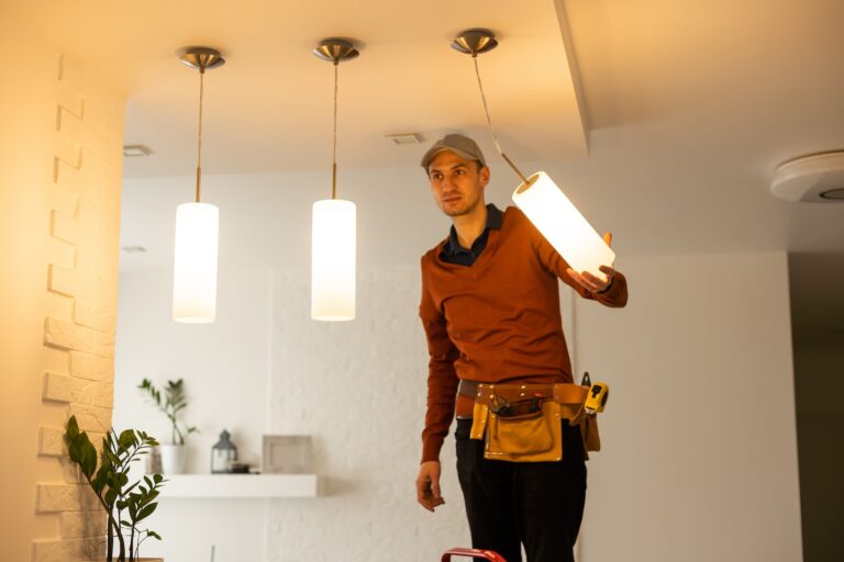 Electrician man working on exterior light, install LED replacement lamp at home. Maintenance concept.